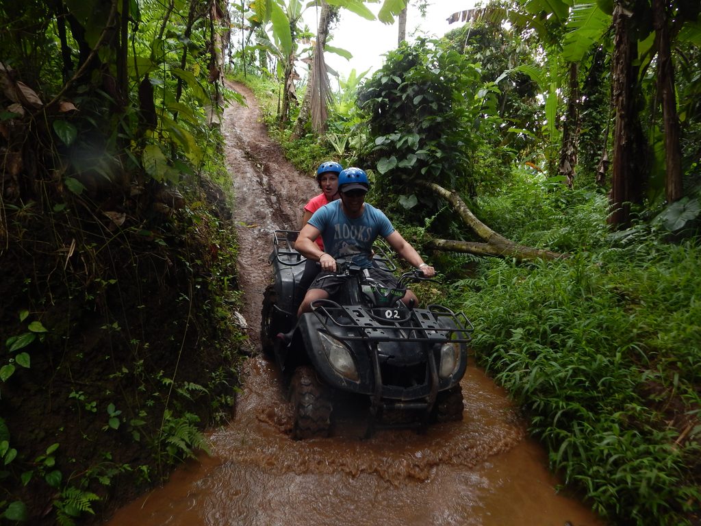 Peserta outing perusahaan mengendarai ATV melewati jalur alam dalam aktivitas adventure di Bali.