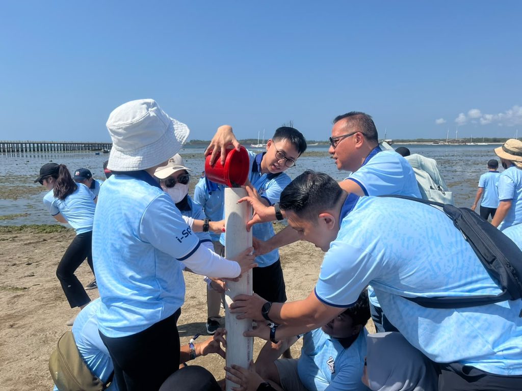 Peserta outing perusahaan mengikuti berbagai beach games dan aktivitas team building di pantai Bali.